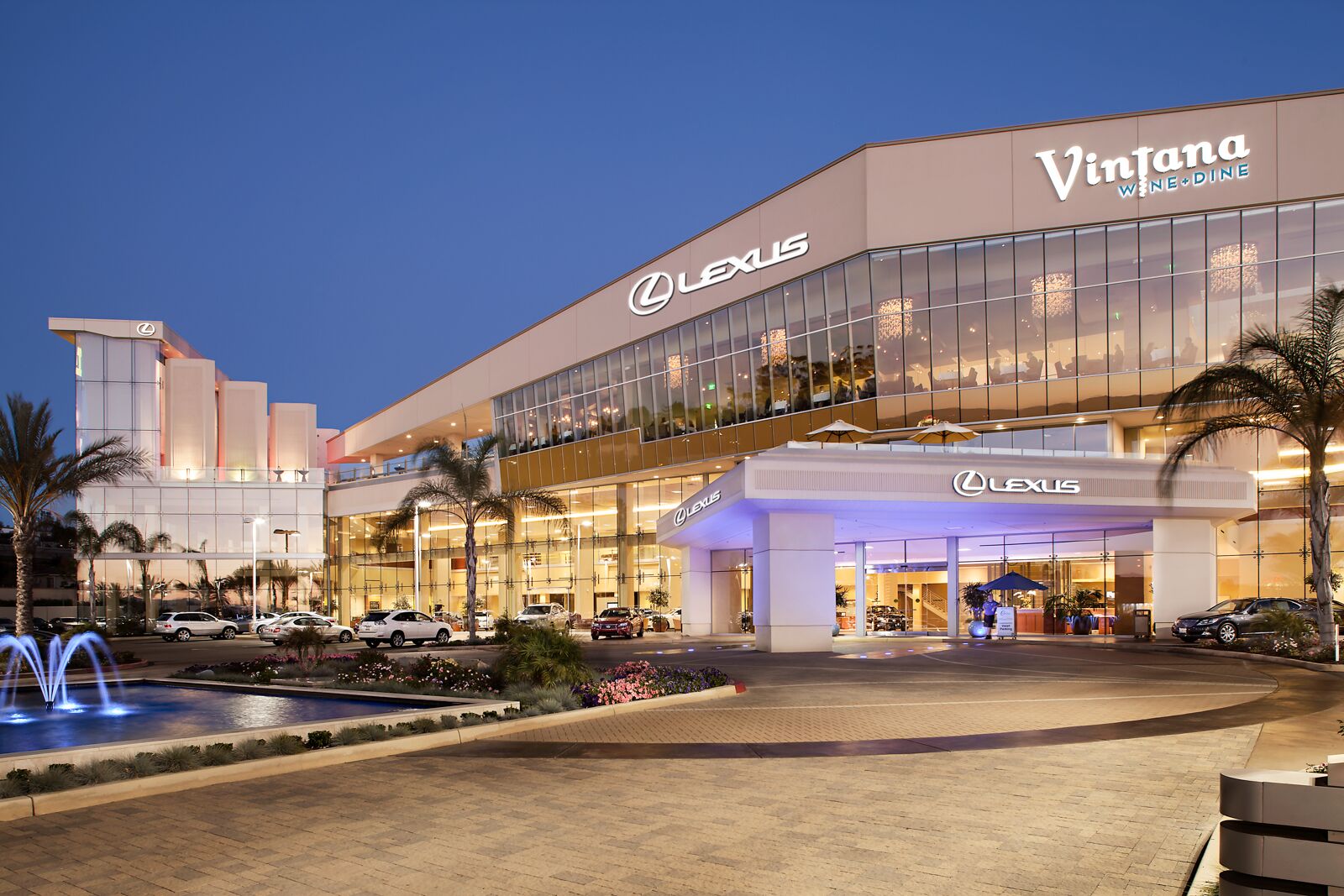 The outside of The Centre Escondido next to the fountain, looking at the front doors. You can see the Lexus and Vintana sign.
