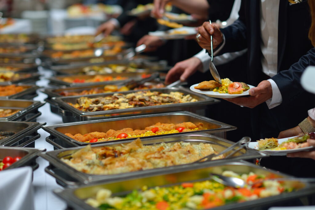 people enjoying around the world buffet food indoor in event venue with meat colorful fruits and vegetables from around the world