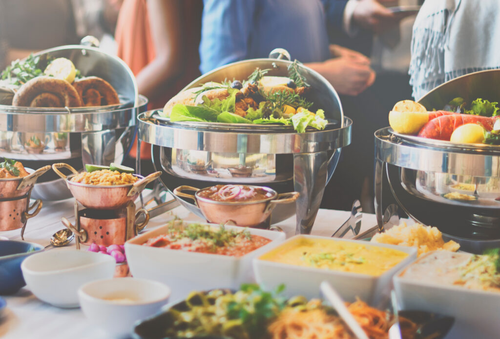 Bridal Luncheon Buffet Brunch Spread laid out on a buffet line with guests grabbing food for their plates in the background.