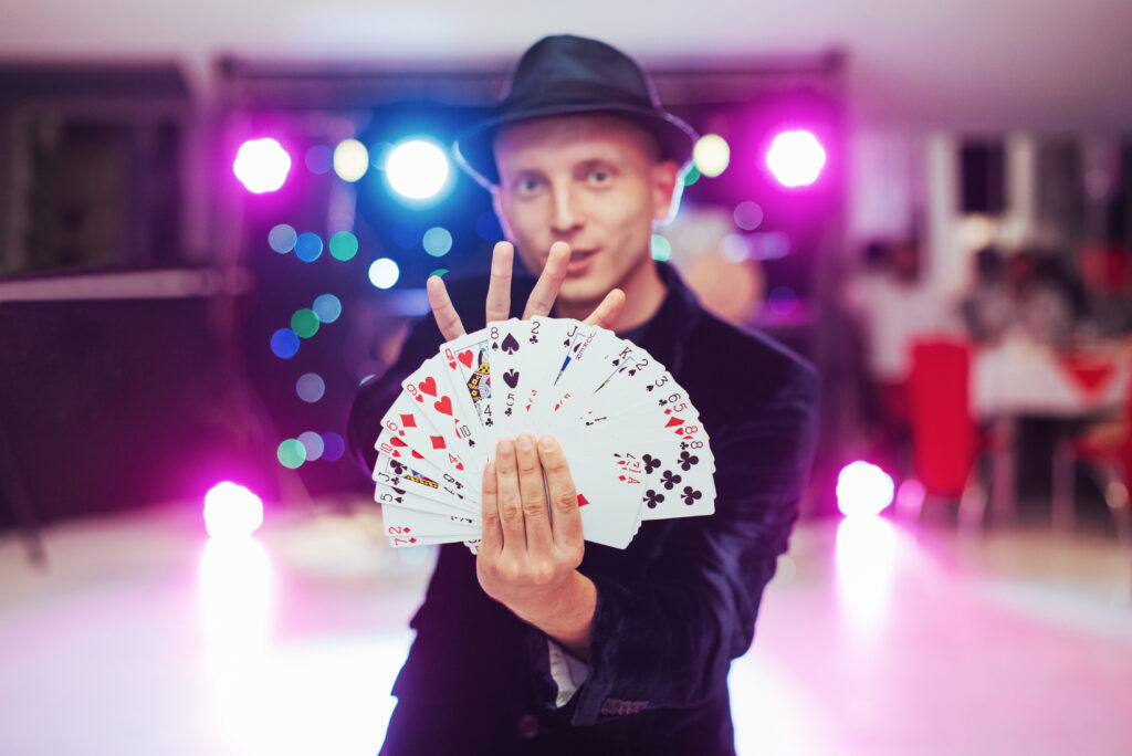 Magician showing trick with playing cards. 