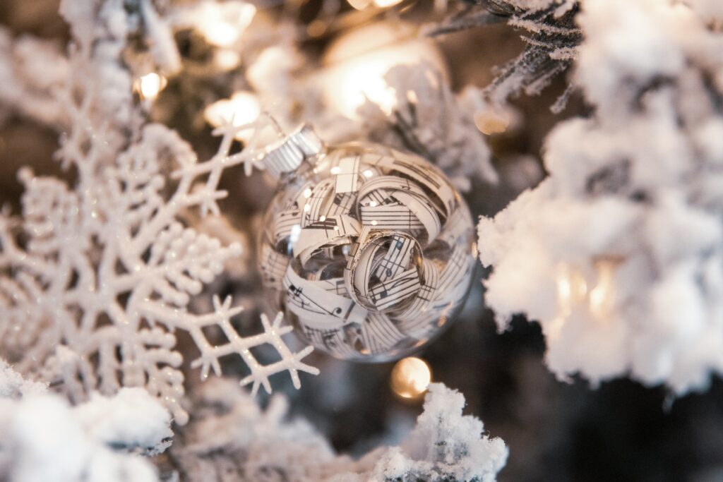 A close up photo of corporate holiday party winter wonderland decor with a white snowflake and silver and white holiday bulb
