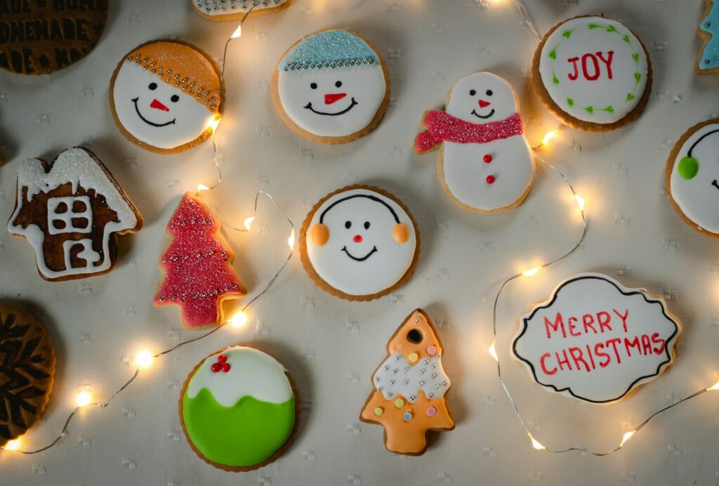 Decorated cookies from a cookie decorating party. 3 snowmen faces, a snow man, "merry christmas" ornament, and a cookie showcasing the year. 