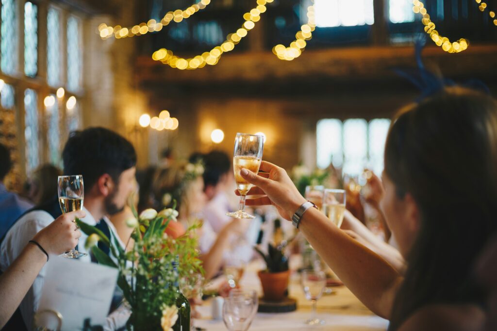 Guests at a holiday party giving a cheers to celebrate the year
