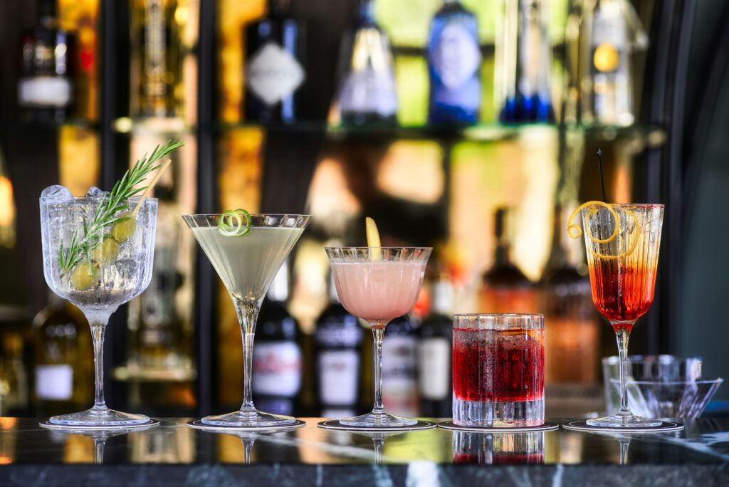 Cocktails lining a bar to illustrate the need for a drink menu at a corporate event